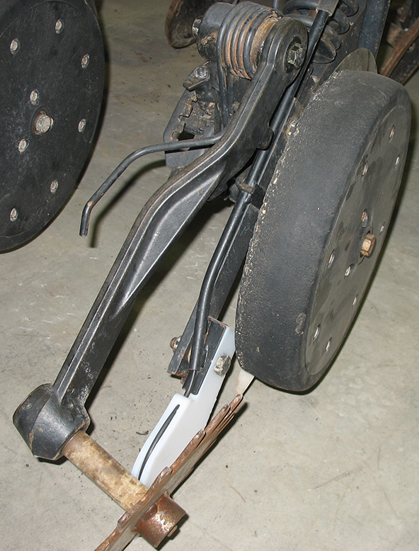 The Fin installed onto the firming wheel arm of a JD 1890 drill.