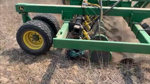 Close up of John Deere drill with UniForce in a field.