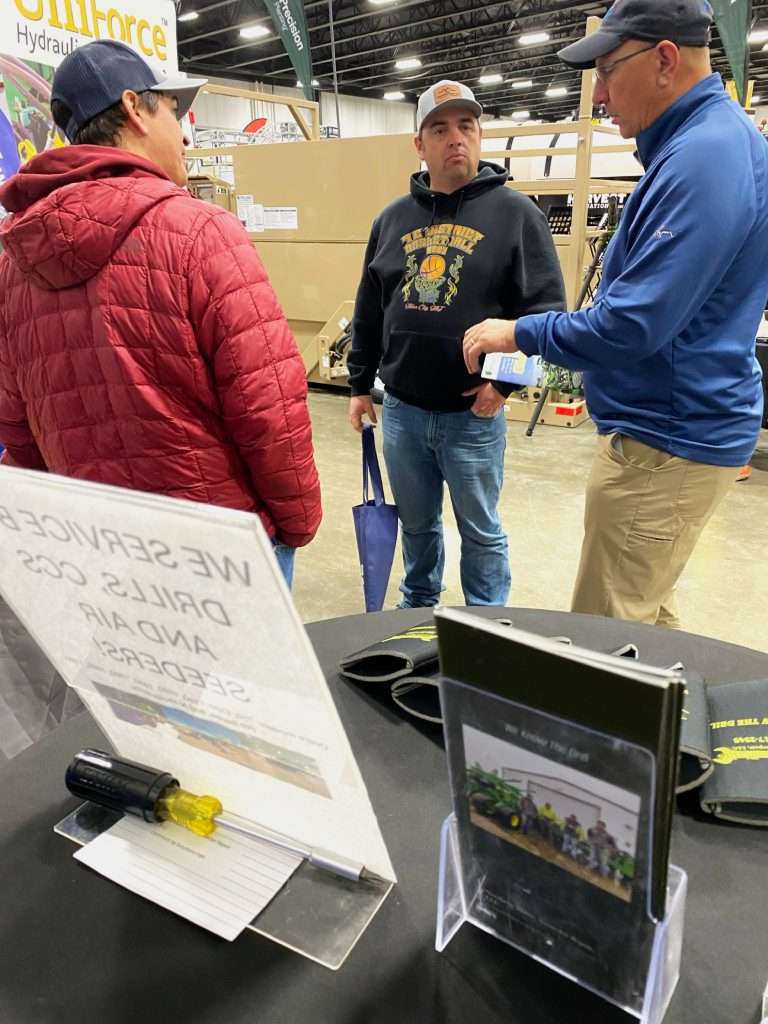 Salesman talking with customers at a farm show.